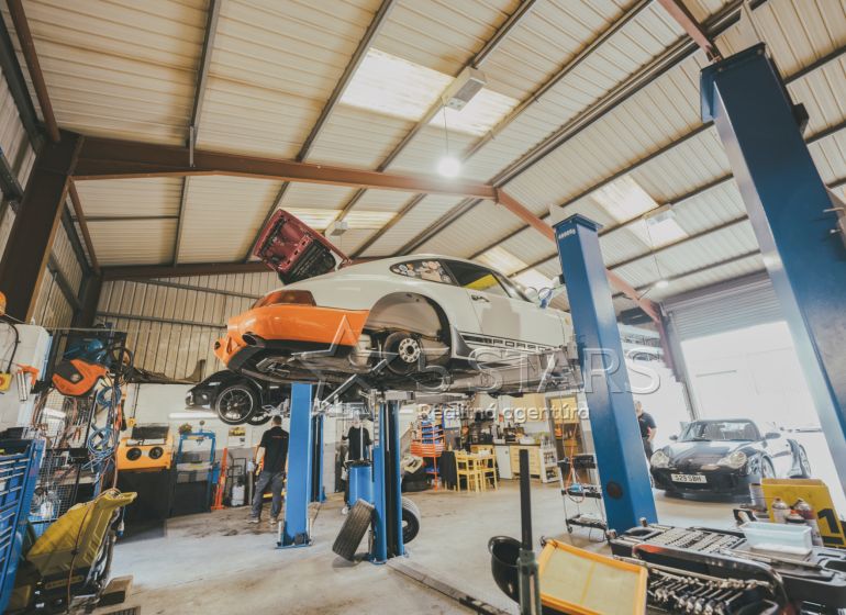 Auto service with two lifts, vehicles, and tools in the space of special properties.