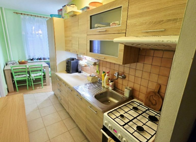A kitchen in a 4-room apartment with a wooden decor and a dining nook.