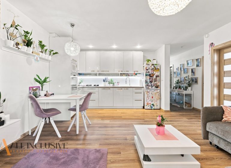 Interior of a family house with a kitchen, dining table, and floor with wooden decor.