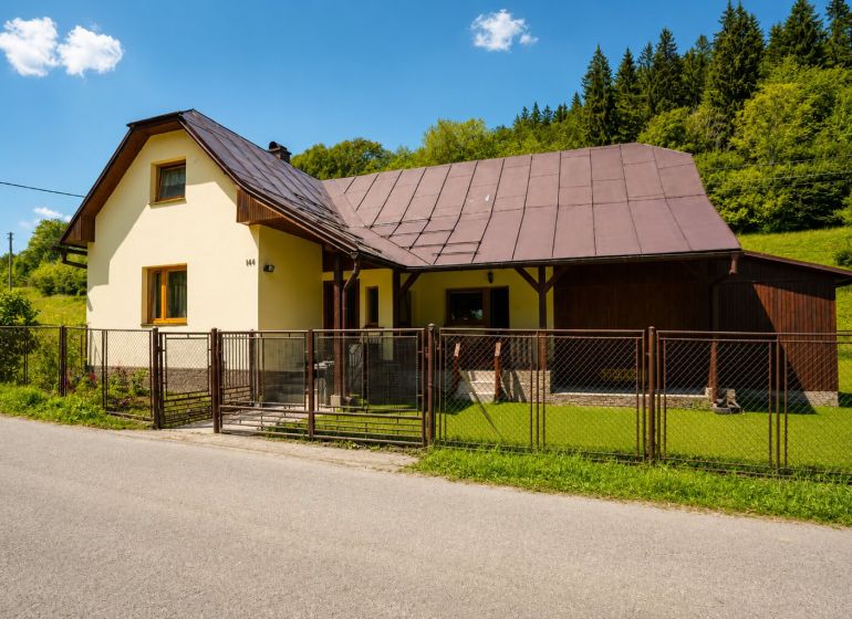 A cottage on Čierne Street in Makov with an ornamental lawn and a wooden fence.
