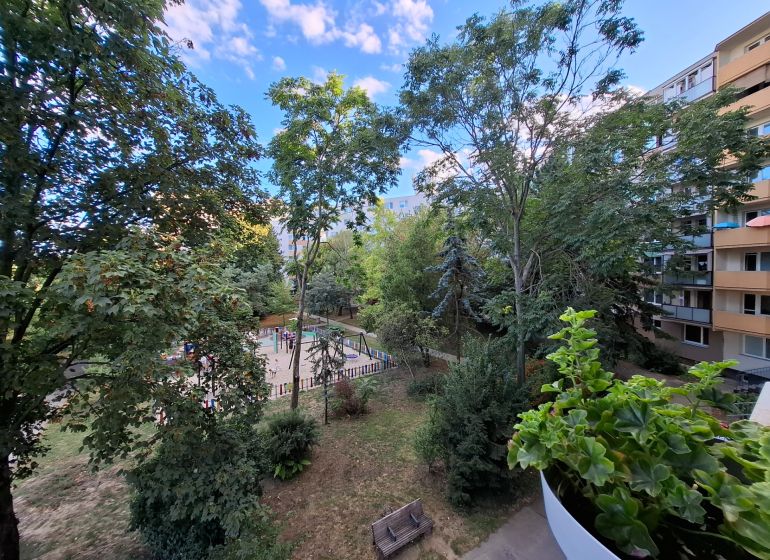 View from the balcony of a 3-room apartment on Hospodárska Street in Trnava, with a playground and trees.