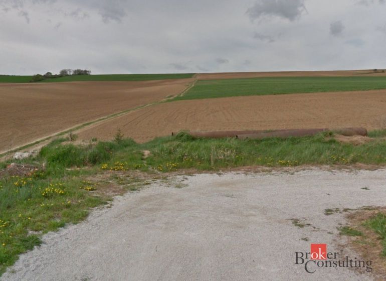 Land near Lužianky suitable for plots - housing, with a field and meadow in the background.