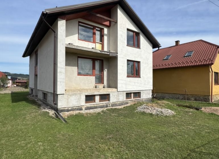 A family house in Plavnica with a green lawn and a partially finished facade.