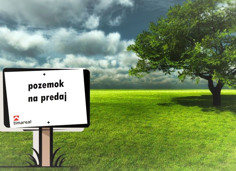 The board announces the sale of land, a green lawn next to a tree is displayed.