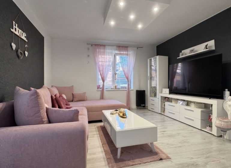 Living room in a family house with a pink sofa and decorations.