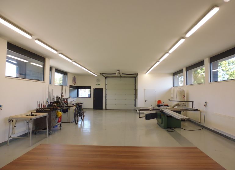 Interiors of warehouses and halls with equipment, white walls, and floors with wood decor.