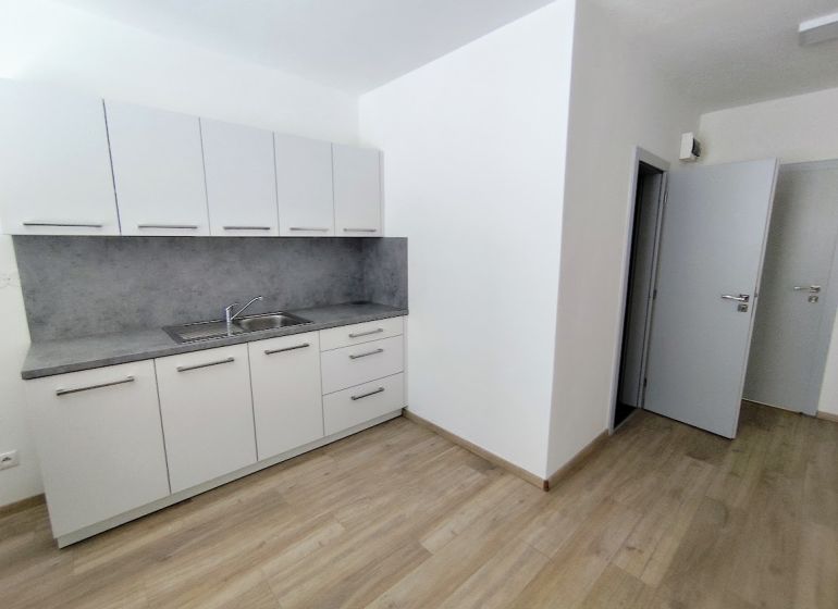 White cabinets with a countertop, floor with wood decor in the office.
