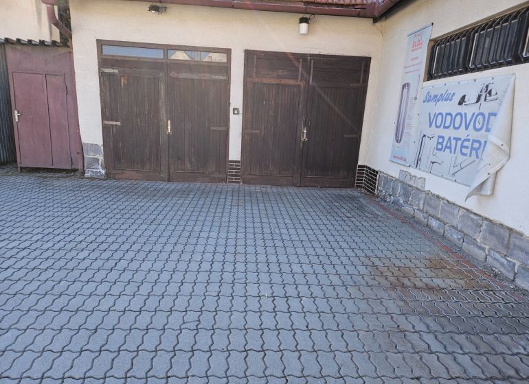 Wooden garage doors on Metodova Street in Prešov, paved yard.