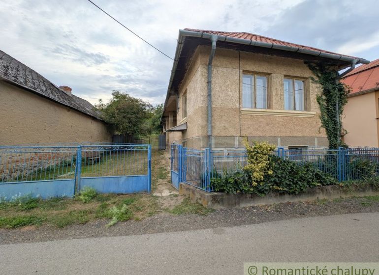 A family house in Nižné Ladičkovce with a garden, fence, and shingle roof.