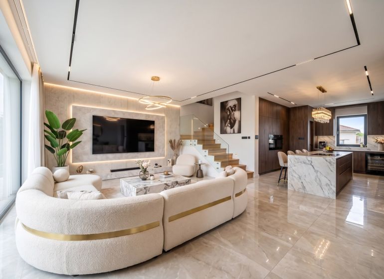 Open space with a kitchen, staircase, and comfortable living room in a family house.