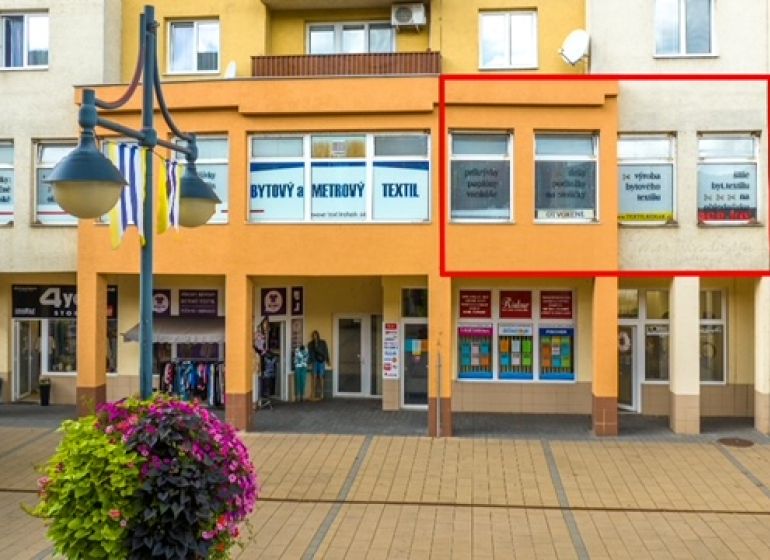 Commercial premises on Moyzesova Street in Púchov with shops and floral decorations.
