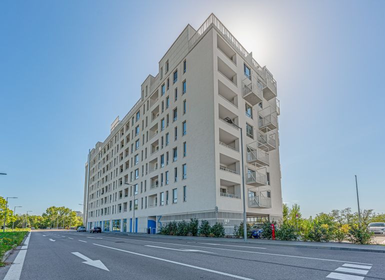 Residential building on Labutia Street in Bratislava, Petržalka, with sunlight in the background.