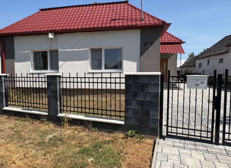 A family house on Hlavná Street in Bežovce with a red roof and a wrought iron fence.