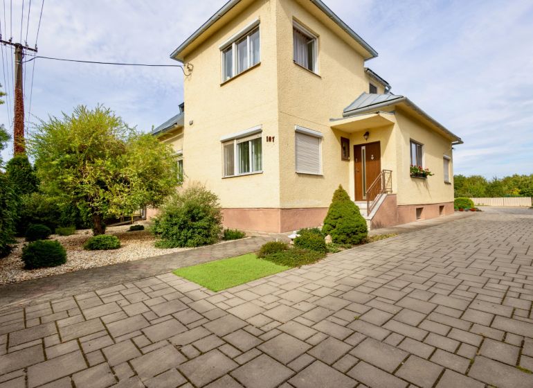 A family house on Topolianska Street in Michalovce with a landscaped garden and paving.