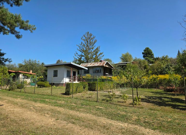 A cottage on Popradská Street in Košice West surrounded by greenery and a grassy plot.