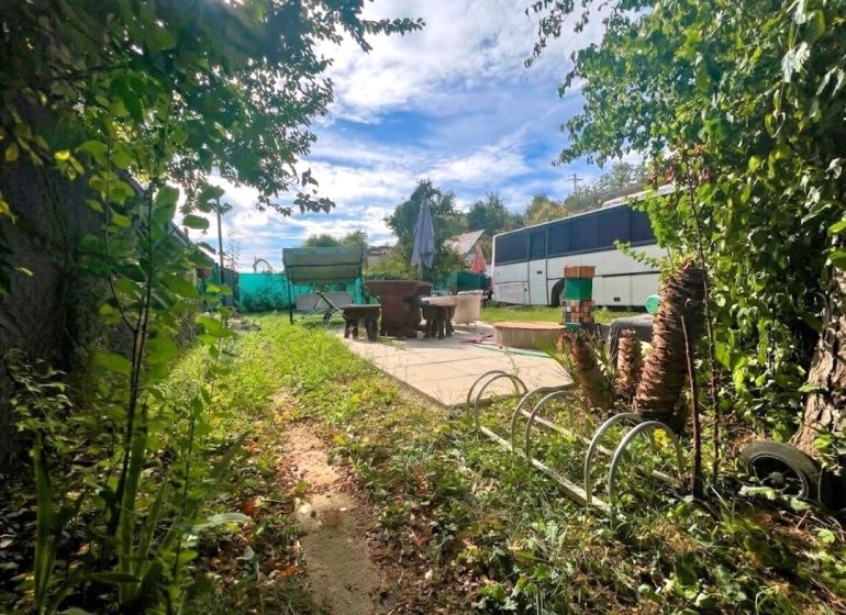 A garden with a terrace and benches around the cottage near Bánovce nad Bebravou.