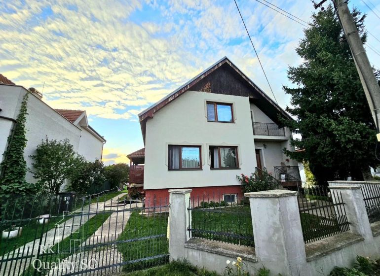 A family house in Tureň on Tureň Street surrounded by a garden and a blue sky.
