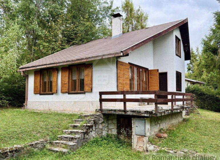 A cottage in Košická Belá with a stone staircase and wooden shutters in a natural setting.