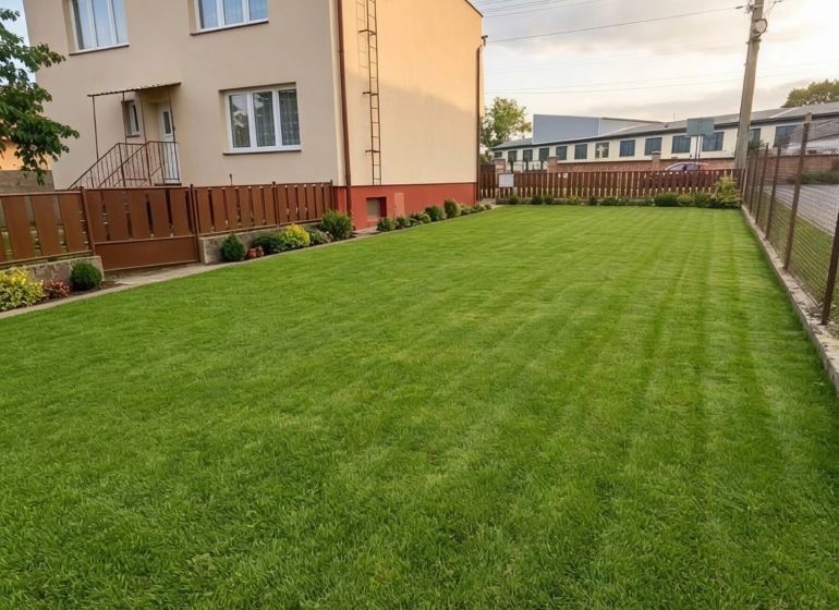 A family house in Záhorská Ves with a manicured lawn and simple fencing.
