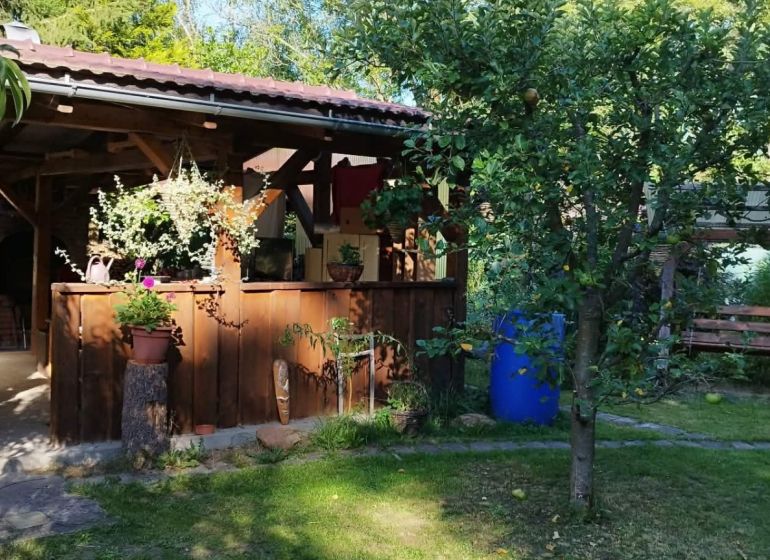 A cottage in Lutila with a wooden terrace, a swinging bench, and surrounding greenery.