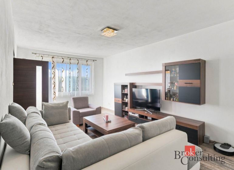 A kitchen in a 2-room apartment with a wooden floor decor and stainless steel appliances.