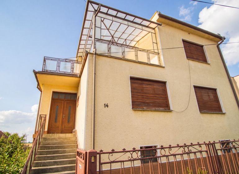 A family house in Dvory nad Žitavou with wooden shutters and a spacious terrace.