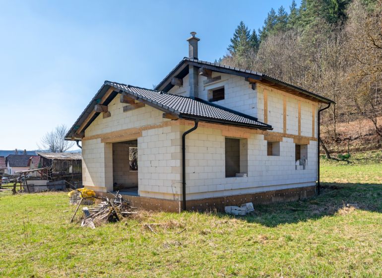 A family house in Lazy pod Makytou, an unfinished building surrounded by nature and greenery.