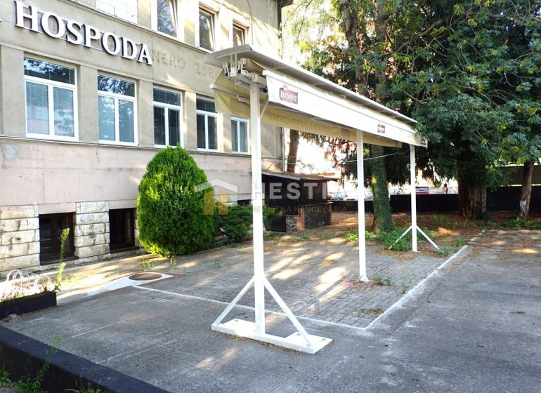Commercial premises in Senica with parking, greenery, and a sign on the building.
