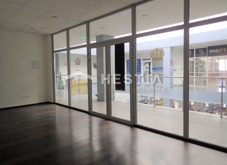 A glazed interior of a 2-room apartment with a wooden decor floor and a view into the hallway.