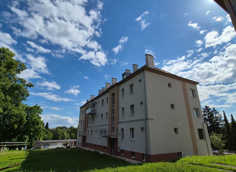 An apartment building with a lawn and a clear sky on Kpt. Uhra Street in Myjava.