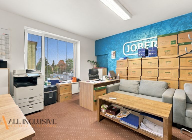Offices with a sofa, boxes, and a printer, wooden decor flooring, blue wall.