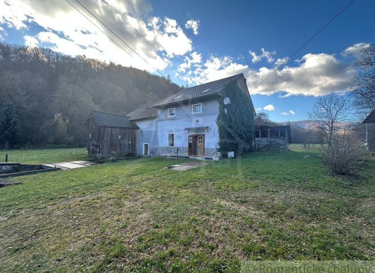 A family house in Mokrá Lúka surrounded by nature, green lawn, blue sky.