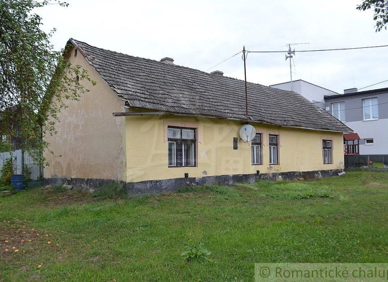Yellow family house in Nemcovce with a grassy plot and a satellite dish.