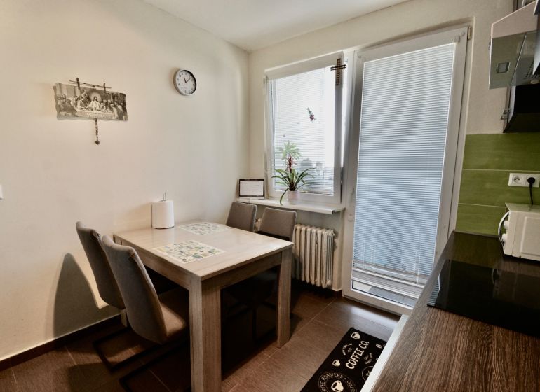 Kitchen in a 3-room apartment with a dining table and chairs, light decoration.