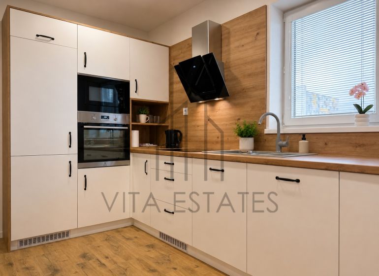 A kitchen with white cabinets and a wood-patterned floor in a 3-room apartment.