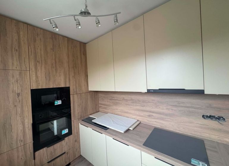 Kitchen in a 2-room apartment with storage cabinets and a built-in oven.