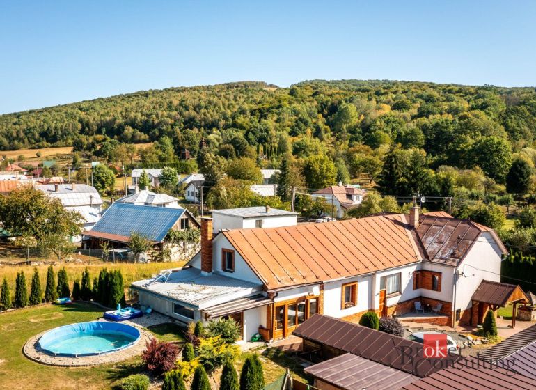 A family house in Potoky surrounded by a garden with a swimming pool and hilly nature.