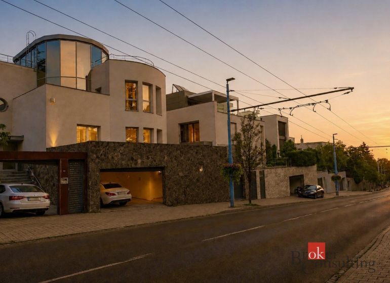 A villa in Bratislava-Old Town illuminated at night, surrounded by a stone fence.