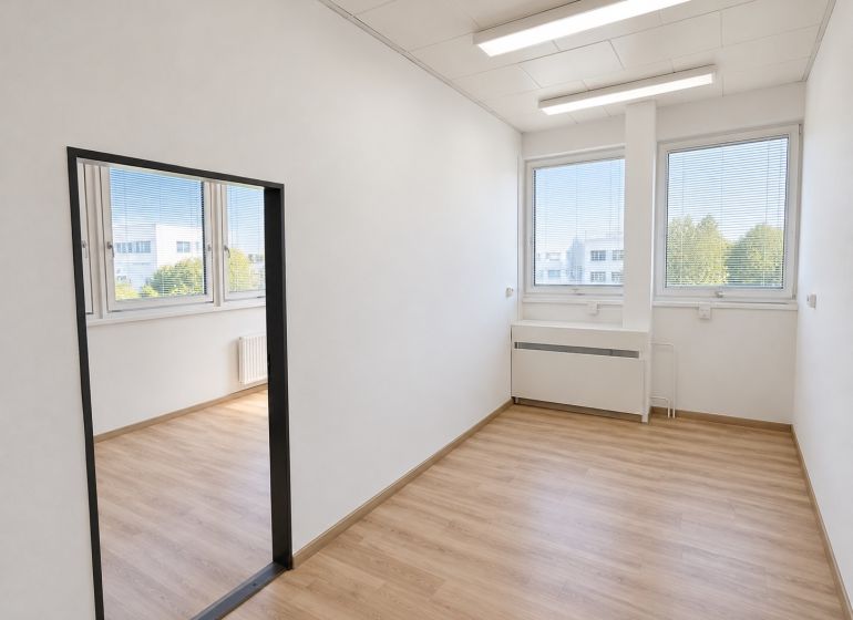 Offices with large windows and wooden decor flooring.