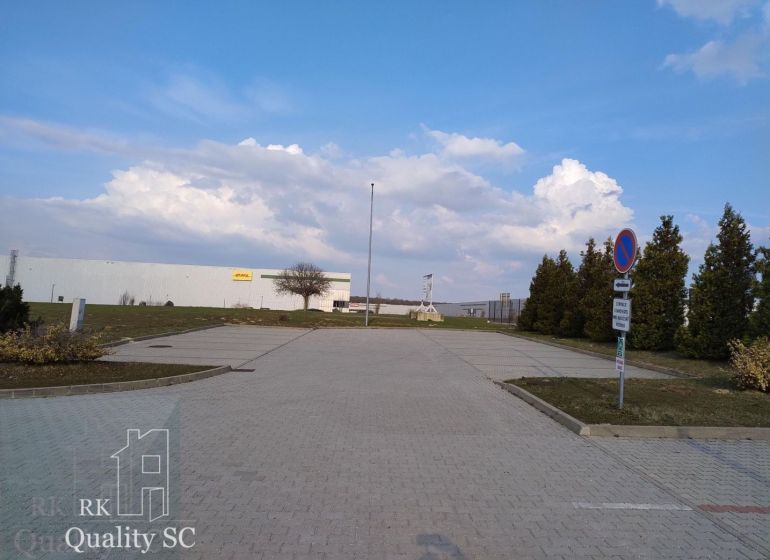 Exterior in Senec with offices, parking lot, and blue sky.