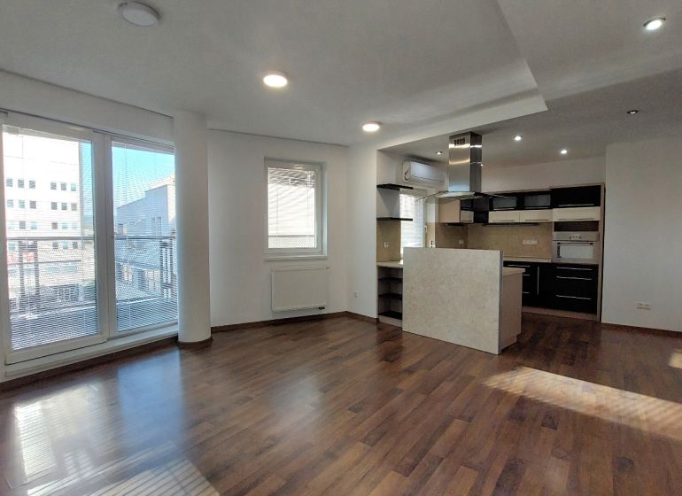 Spacious interior of a 2-room apartment with a kitchen and a wooden decor floor.