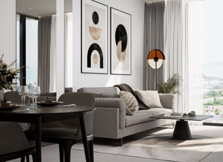 A bright interior of a 2-room apartment with a comfortable sofa and decorative paintings on the wall.