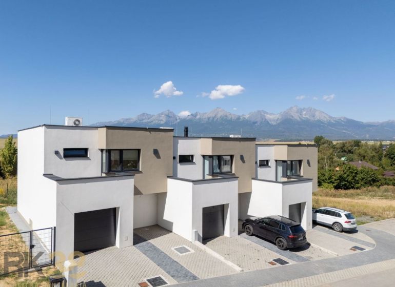 Poprad apartment buildings with the panorama of the High Tatras on the horizon, surrounded by nature.