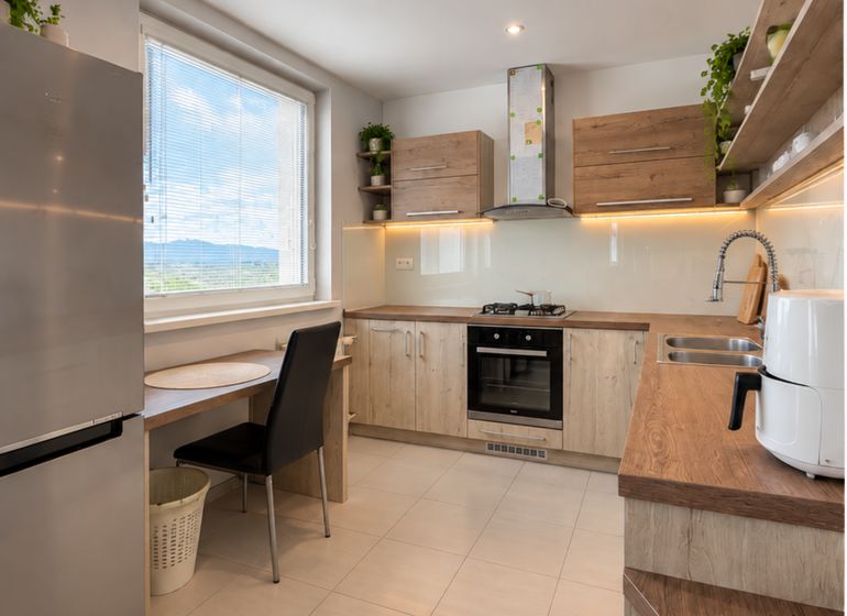 A kitchen with a wooden decor floor in a 4-room apartment, bright and spacious.