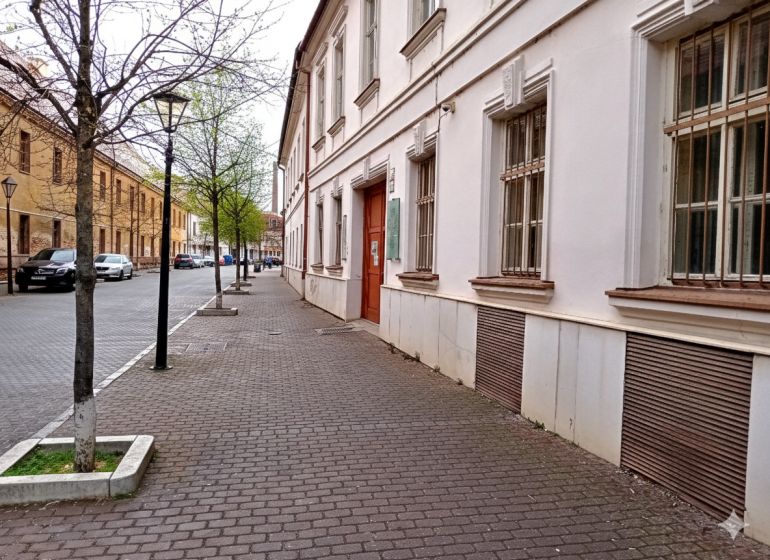Františkánska Street in Trnava with historic buildings and trees near the offices.