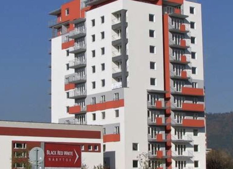 High-rise building on Obchodná Street in Žilina with a light facade and balconies.