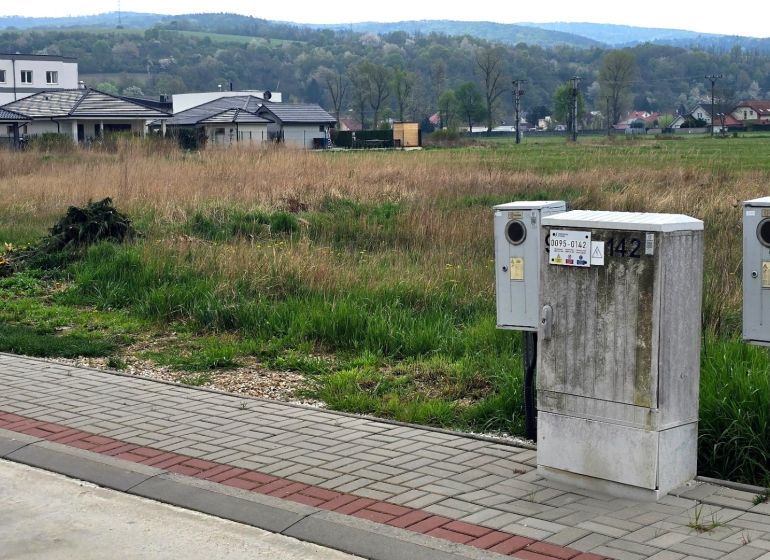 Flat residential plots in Banka with electrical distribution boxes in the foreground.