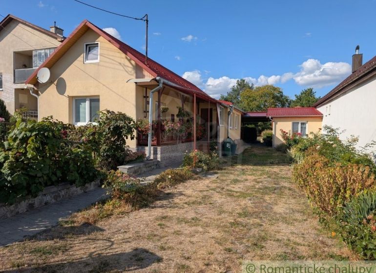 A family house in Cabov with a red roof, a front garden, and a paved walkway.