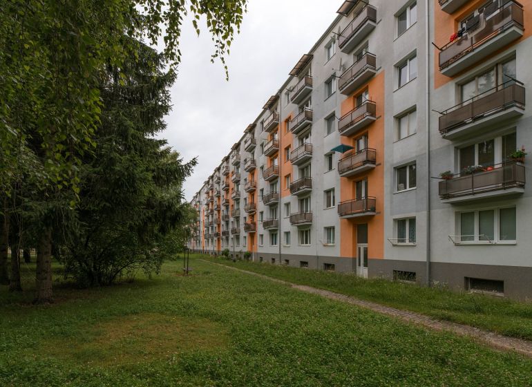 An apartment building on 28. októbra Street in Trenčín surrounded by greenery.