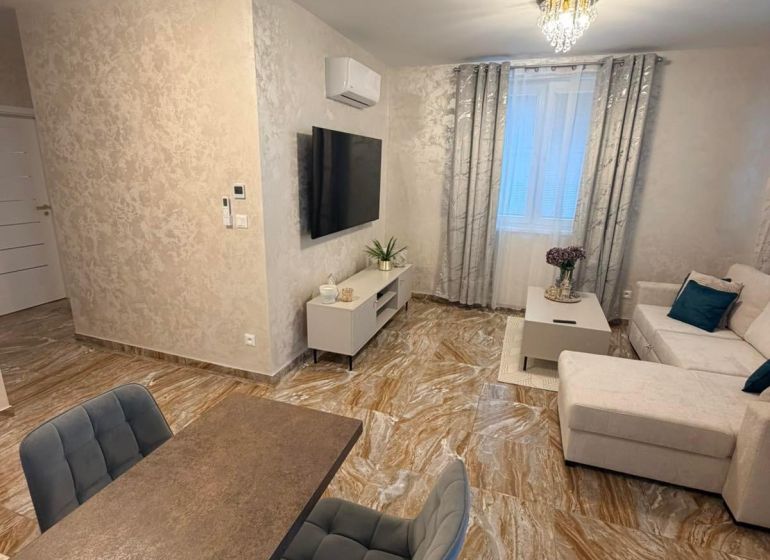 Living room in a 3-room apartment with glossy tiles and comfortable seating.
